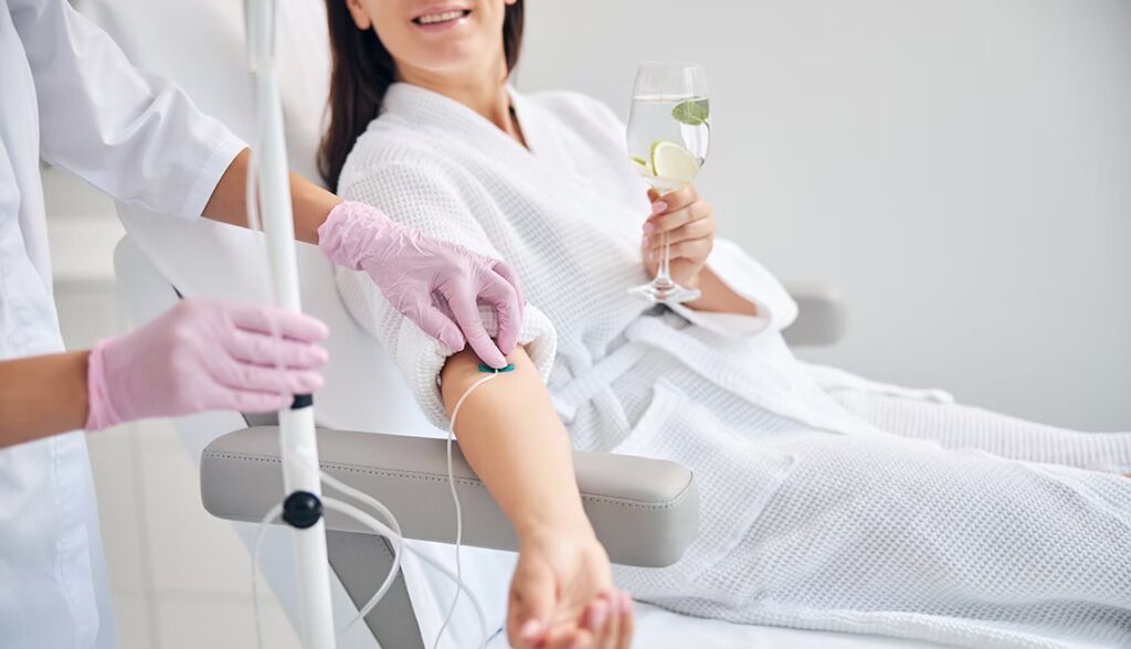 Young female in white bathrobe during medical procedure in beauty clinic