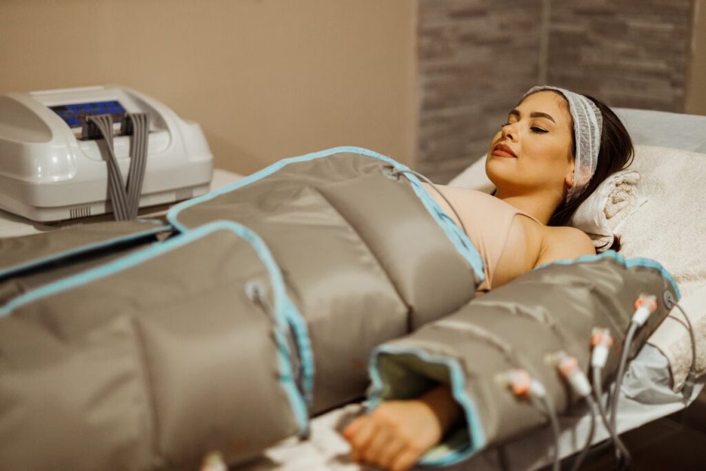 Young woman having a pressotherapy treatment in the beauty clinic